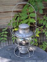 Full view of lantern showing handle, wire guard and globe