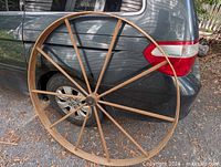 Full view of wheel leaning against vehicle showing size and 12-spoke construction