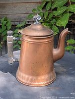 Full view of copper coffee pot showing spout, handle, lid finial