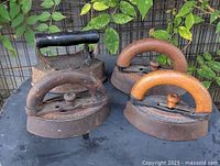 Four cast iron sad irons grouped on table