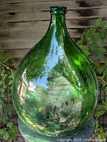 Full view of large green demijohn bottle showing shape and color