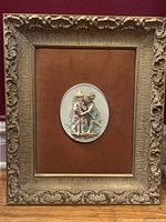 Front view first framed porcelain cherub plaque showing frame, velvet mat and cameo