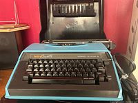 Front view of Brother 4712 electric typewriter with cover opened behind
