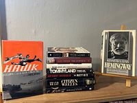 Front view showing Tony Hawk hardcover, stack of other biographies, and Hemingway on easel