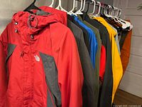 Row of seven North Face jackets hanging