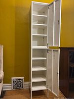 Full view of stacked white metal lockers, doors open showing shelves