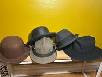 Four hats lined on bench showing overall styles and colours