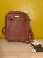 Front view of brown Samsonite shoulder bag showing zip pocket and strap