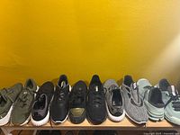Eight pairs shoes lined on shelf