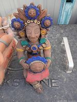 Full view of painted clay Aztec-style figurine on tabletop
