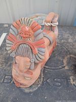Full view of the Aztec-style terracotta figure lying on surface