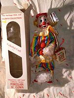Front view of porcelain clown figure beside original box