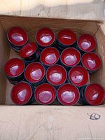 Open box showing stacks of red-inside black plastic soup bowls