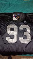 Front of black jersey showing silver 93 numerals and attached tag