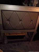 Front view of one twin headboard showing diamond-tufted upholstered panel and frame