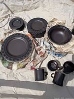 Full set of Pfaltzgraff Midnight Sun dishes laid out showing plates, bowls, mugs
