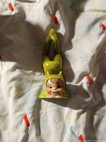 Front view of ceramic devil elf figurine lying prone