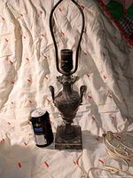 Front view of brass lamp next to can for scale