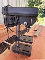 Left side view of Craftsman bench drill press showing entire unit, cord, base and table