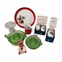 Group shot showing all items: three egg coddlers in boxes, two green glass reamers, pie funnel figure, clear glass sugar dish, Arnart plate and mug