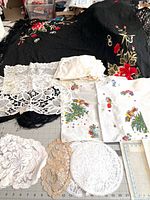 Overall view showing piano shawl, lace runner, pillow sham, Christmas towels, multiple doilies