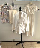 Group shot of all four clothing items: dress, blazer on mannequin, blouse, pants