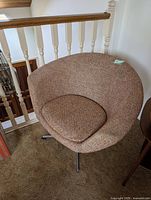 Full view of swivel armchair showing upholstery and shape