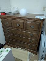 Front view of oak dresser showing all drawers and brass pulls