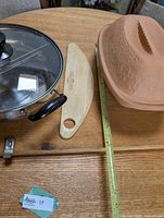 Terracotta clay baker, wooden pizza board, partial view of stainless split hot pot