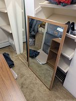 Full view of rectangular mirror leaning against wall