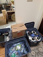 Three storage totes and a box containing electronic items