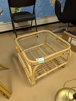 Full view of bamboo table with glass top and lower shelf