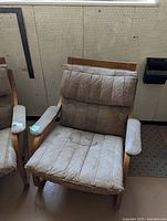 Front view of first armchair showing leather staining and teak arms