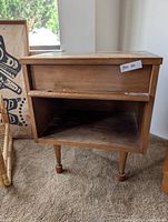 Front view showing drawer, open shelf, legs