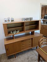 Full view of teak credenza with upper hutch and sample decor items for scale