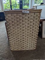 Front view of rectangular wicker laundry basket with lid closed