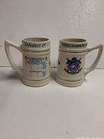 Front view of both ceramic mugs showing team crest and bracket