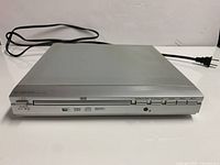 Front view of Curtis DVD 1047 player showing full unit and power cord