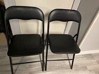 Front view of both black folding chairs