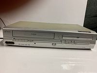 Front view showing VHS slot, DVD tray, full control panel and overall wear