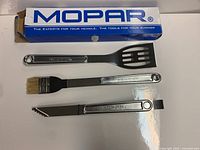 Three stainless steel BBQ utensils with Mopar box