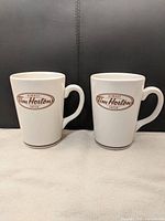 Front view of two white Tim Hortons Always Fresh mugs