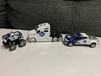 Three Toronto Maple Leafs die-cast vehicles lined up