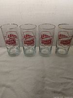 Four tumblers showing red TTC streetcar graphic with gold rim