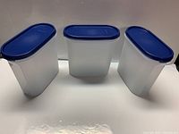 Front view of three matching canisters showing size and lids