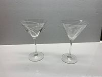Both martini glasses side by side showing size and etched patterns