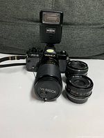 Front view of FX-3 camera with telephoto lens, two extra lenses and flash attached