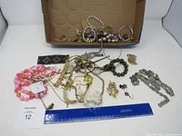 Overview of all jewelry spread out with ruler for scale