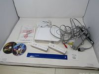 Overall lot view with console, controllers, discs, cables and accessories