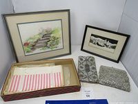 Overall lot view showing framed pictures, clutches, gift bags and box